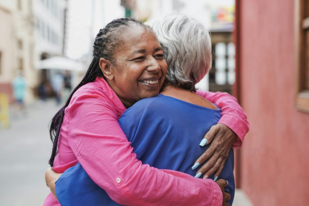 Elderly multiracial women hugging each other - Friendship, love and senior people concept