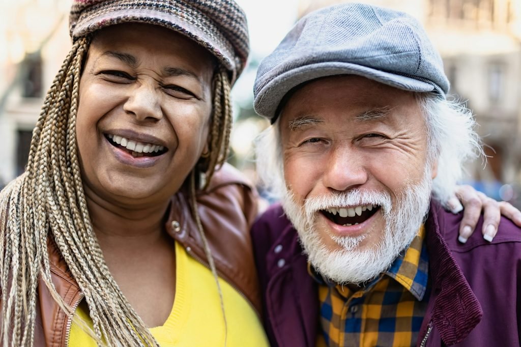 Happy multiracial senior couple having fun in city - Elderly people and love relationship concept